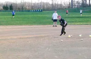 Manager Ron Brown pitching  batting practice.